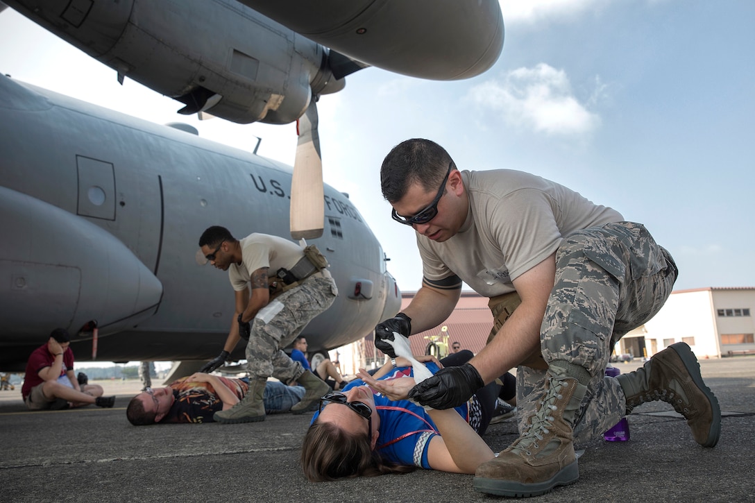 Air Force Senior Airmen Jonathan Rodriguez, right, and Richson Bacay provide medical aid to mock casualties during a major accident response exercise at Yokota Air Base, Japan, July 10, 2017. Rodriguez and Bacay are aerospace medical technicians assigned to the 374th Medical Operations Squadron. Air Force photo by Yasuo Osakabe
