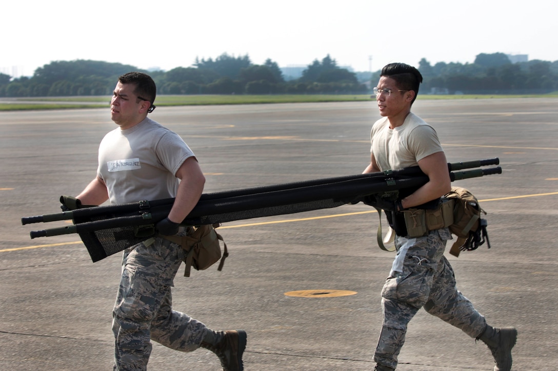 Air Force Senior Airmen Richson Bacay and Jonathan Rodriguez carry a stretcher during a major accident response exercise at Yokota Air Base, Japan, July 10, 2017. Air Force photo by Yasuo Osakabe