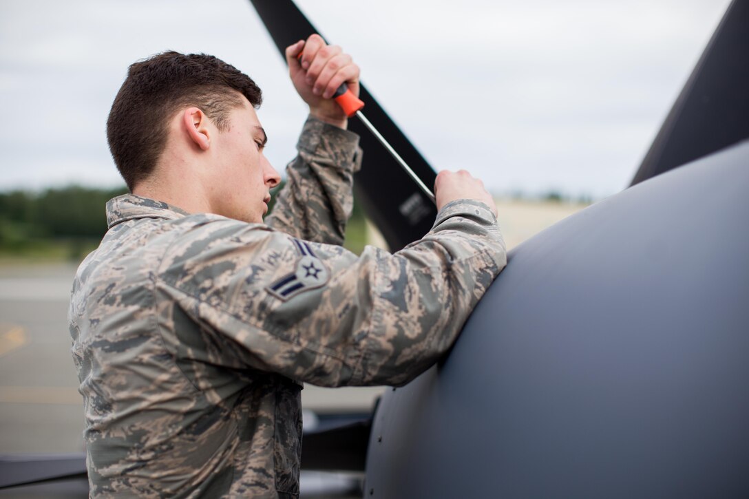 Air Force Airman 1st Class Trevor Galindo, a crew chief for the Alaska Air National Guard's 176th Maintenance Squadron, removes a maintenance panel on an HC-130J Hercules aircraft at Joint Base Elmendorf-Richardson, Alaska, June 28, 2017. Alaska Air National Guard photo by Air Force Staff Sgt. Daniel Bellerive