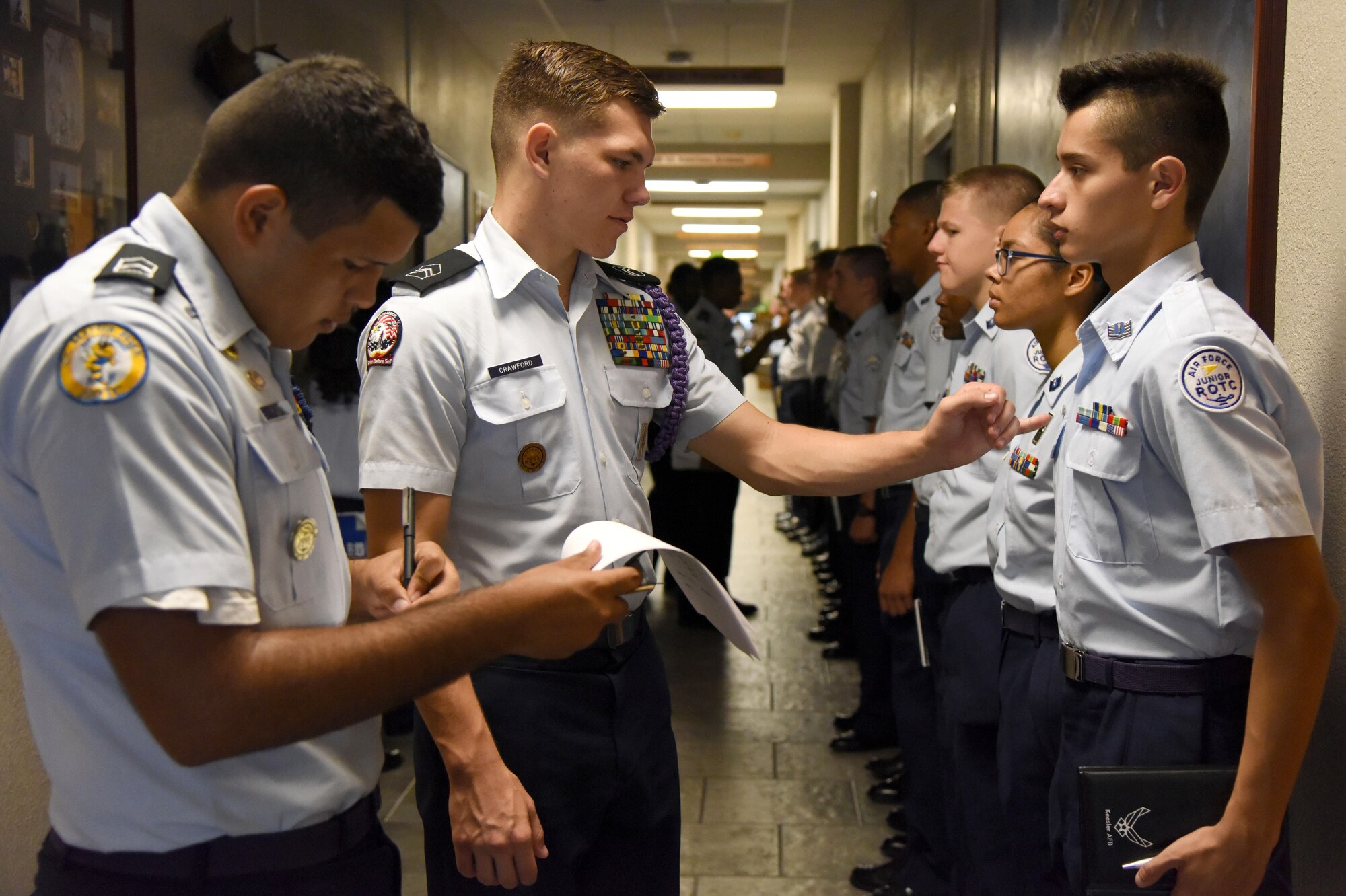 Mississippi Air Force Junior ROTC cadets Natanael Rivera, St. Martin High School, and Kane Crawford, Bay High School, Bay St. Louis, conduct a uniform inspection on Jose Martinez, Biloxi High School, during a JROTC Cadet Leadership Course at the Mathies NCO Academy July 12, 2017, on Keesler Air Force Base, Miss. Approximately 140 JROTC students from 15 high schools in five states attended the week-long course at Keesler that ended with a parade and graduation ceremony. (U.S. Air Force photo by Kemberly Groue)