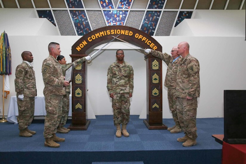 Sgt. Joshua Yerby, a Soldier with U.S. Army Central, crosses the “Time-Honored Line” arch complete with crossed sabers during an noncommissioned officer induction ceremony held at Camp As Sayliyah, Qatar, July 1, 2017. Thirty-eight U.S. Army Central Soldiers assigned to the 3rd Medical Command (Deployment Support), 1st Theater Sustainment Command, and the Missouri Army National Guard’s 1st Bn, 138 Inf. Regt., participated in the ceremony.  (U.S. Army photo by Vincent Cummings)