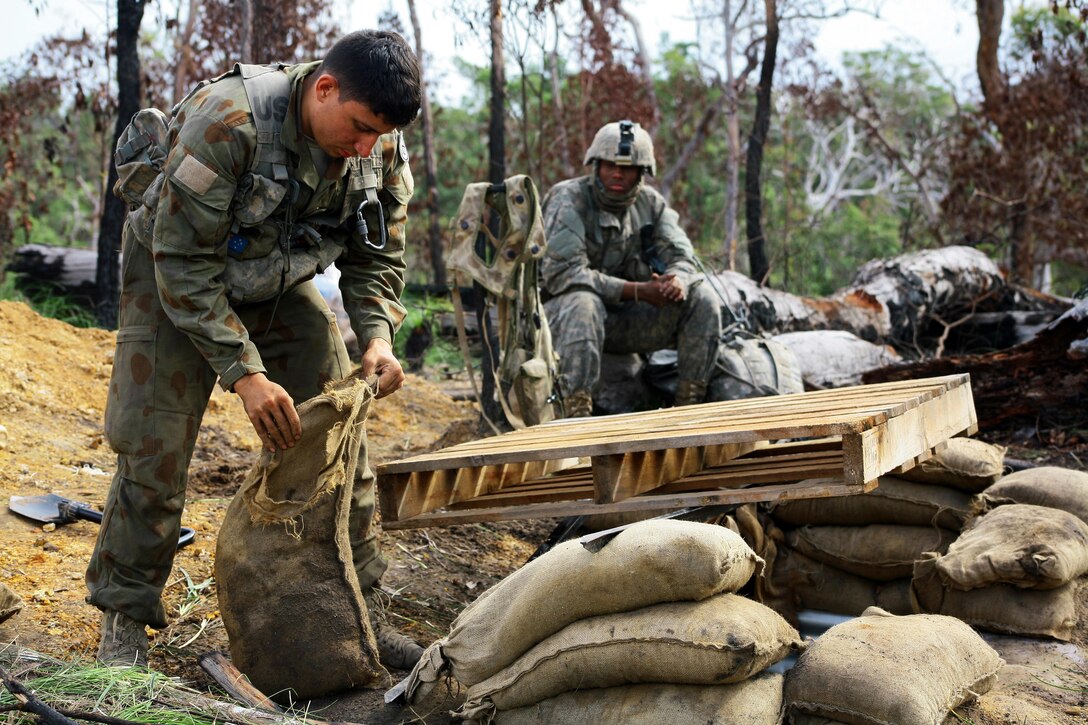 Army 2nd Lt. Matthew Canavan helps fill sandbags to improve his fighting position during exercise Talisman Saber at Shoalwater Bay, Queensland, Australia, July 14, 2017. Army National Guard photo by Sgt. Alexander Rector