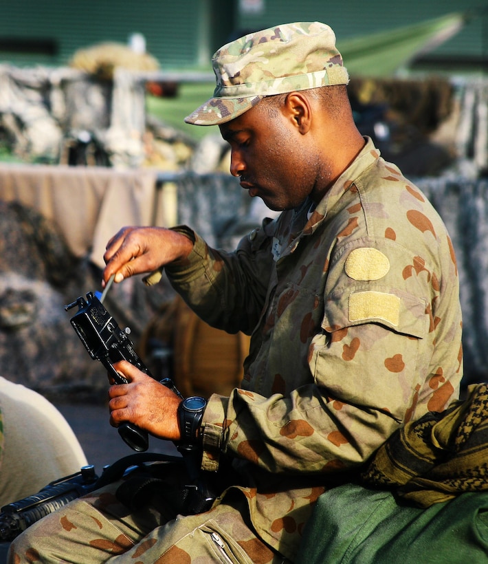 Army Spc. Andrew Jackson cleans his M4 carbine during exercise Talisman Saber at Shoalwater Bay, Queensland, Australia, July 15, 2017. Jackson is an indirect-fire infantryman assigned to Charlie Troop, 2nd Battalion, 101st Cavalry Squadron of the New York Army National Guard. Army National Guard photo by Sgt. Alexander Rector