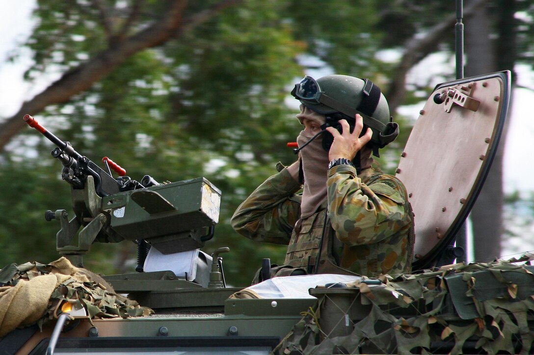 An Australian army soldier scans his sector while manning a machine gun atop a protected mobility vehicle while on patrol during exercise Talisman Saber at Shoalwater Bay, Queensland, Australia, July 15, 2017. Army National Guard photo by Sgt. Alexander Rector