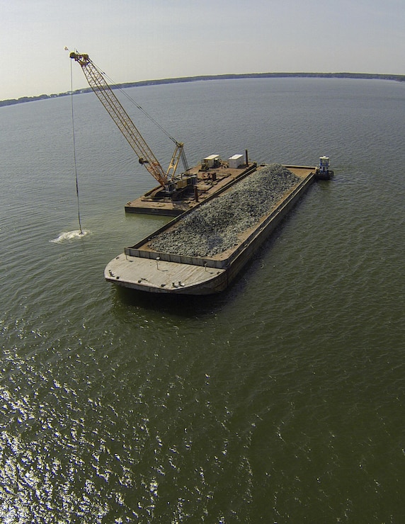 Granite rock, which is brought in by barge, is methodically placed in the Piankatank River near Gwynn’s Island in Mathews County Virginia. The rock is the basis for the newest, 25-acre oyster reef in the Chesapeake Bay Watershed. The Norfolk District, U.S. Army Corps of Engineers, is overseeing the more than $2 million sanctuary reef project in partnership with the Virginia Marine Resources Commission and the Nature Conservancy.   (U.S. Army photo/Patrick Bloodgood)