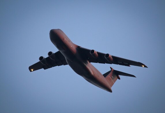 A U.S. Air Force C-5 Galaxy from the 436th Airlift Wing flies over New Jersey while lit by the setting sun. The C-5, one of the largest military aircraft, provides the Air Force with heavy intercontinental strategic airlift capability. The 436th Airlift Wing is located at Dover Air Force Base, Del. (U.S. Air National Guard photo by Tech. Sgt. Matt Hecht/Released)