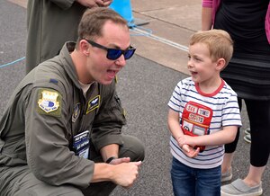 1Lt Travis Carter talks with a young child at the Royal International Air Tattoo in Fairford, U.K.  A crew from the 315th Airlift Wing participated in the three-day airshow.  The airshow celebrated the 70th anniversary of the U.S. Air Force. (U.S. Air Force Photo by Maj. Wayne Capps)