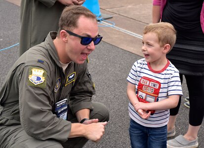 1Lt Travis Carter talks with a young child at the Royal International Air Tattoo in Fairford, U.K.  A crew from the 315th Airlift Wing participated in the three-day airshow.  The airshow celebrated the 70th anniversary of the U.S. Air Force. (U.S. Air Force Photo by Maj. Wayne Capps)