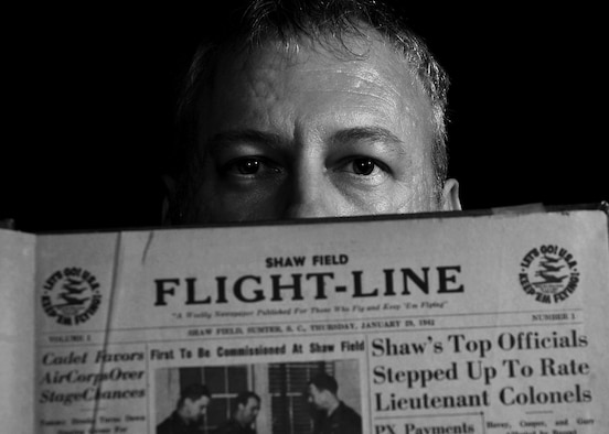 Christopher Koonce, 20th Fighter Wing historian, holds a 1942 edition of the Shaw Field Flight-Line newspaper at Shaw Air Force Base, S.C., July 12, 2017. As the wing historian, Koonce documents the ever-changing warfighter environment, at home and while deployed, by gathering data in historical documents, writing in archives and sharing knowledge with others. (U.S. Air Force photo illustration by Airman 1st Class Kathryn R.C. Reaves)