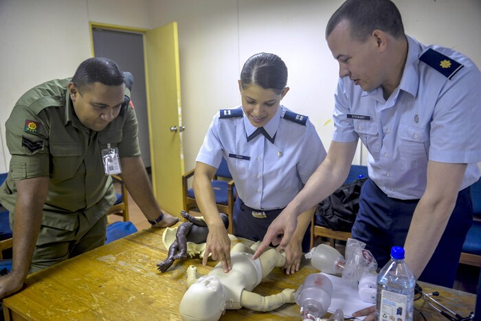 Sgt. Natoga Anitelu, left, a medical services technician with Fiji's military forces, discusses the best ways to clear an infant's airway with Air Force Capt. (Dr.) Paola Rosa, center, and Air Force Maj. (Dr.) Scott Stewart, right, during a subject-matter-expert exchange as part of exercise Pacific Angel 17-3 at a health care center in Ba, Fiji, July 11, 2017. Air Force photo by Capt. Samantha Morrison