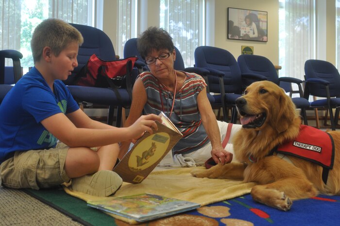 A child reads to a therapy dog during the recent Tales with Tails held at the base library.
