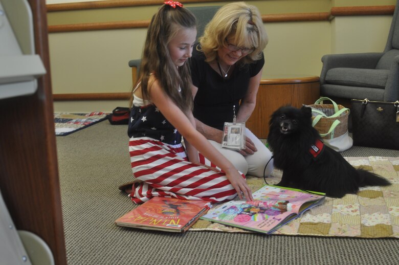 A child reads to a therapy dog during the recent Tales with Tails held at the base library.