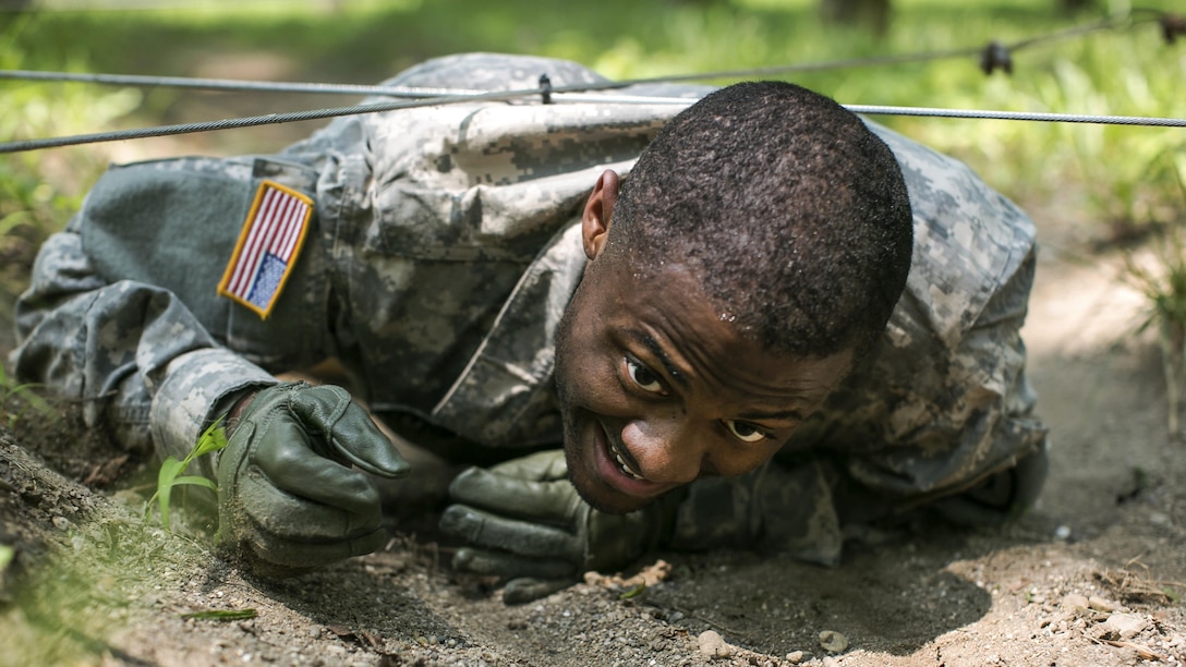 Army Sgt. Luther Witherspoon low-crawls under wires while going through an obstacle course at Camp Atterbury, Ind., July 17, 2017, during the 2017 Army Materiel Command's Best Warrior Competition. Soldiers are tested on basic and advanced warrior tasks and drills during the three-day competition. Army photo by Sgt. 1st Class Teddy Wade