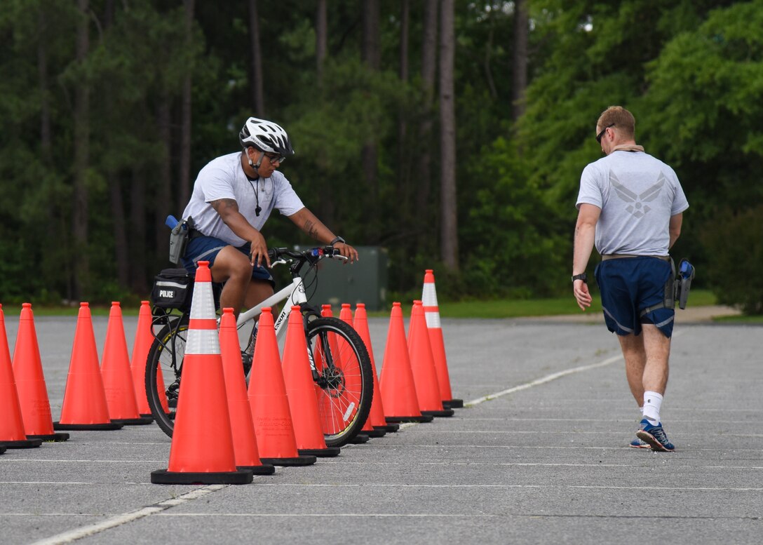(From left) Senior Airmen Sequoyah Singer and Jordan Ryan, 633rd Security Forces Squadron response force leaders, practice maneuvering through traffic cones in Hampton, Va., June 6, 2017. Maneuvering through cones allows 633rd SFS members to practice how to move through traffic and crowds in scenarios where a patrol car would not be effective. (U.S. Air Force photo/Airman 1st Class Anthony Nin Leclerec)