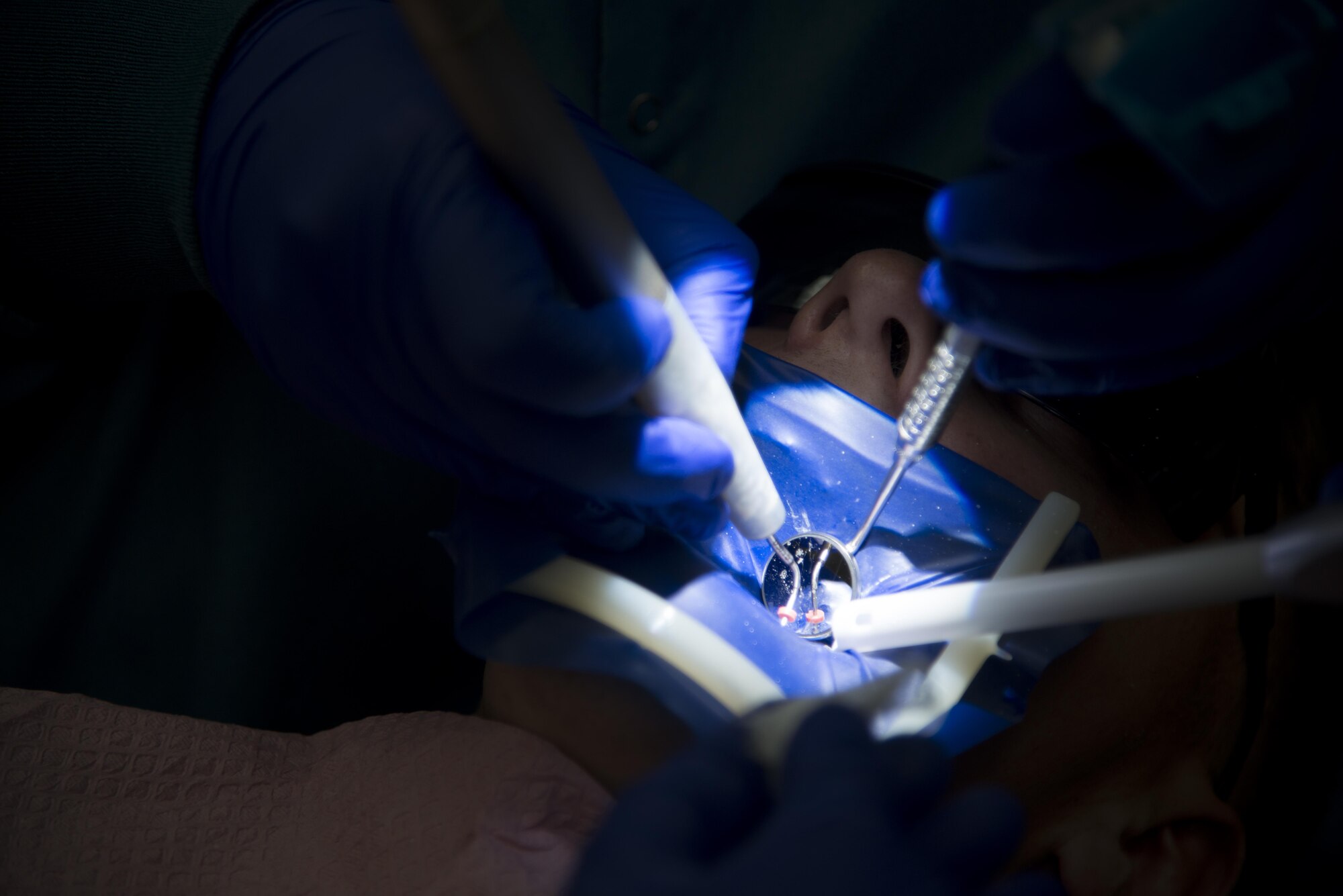 U.S. Air Force Maj. Kelly Ramey, an endodontist assigned to the 6th Dental Squadron, uses a dental lamp to look into her patient’s mouth during a root canal treatment at MacDill Air Force Base, Florida, July 11, 2017. Ramey found her passion for dentistry after visiting a dental clinic during a tour. (U.S. Air Force photo by Senior Airman Mariette Adams)