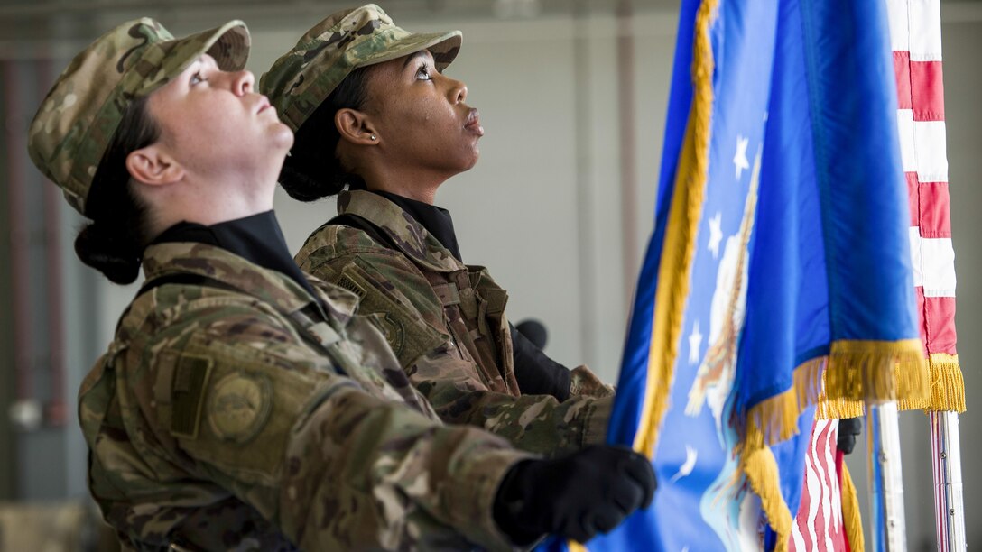 Bagram Honor Guard members set the Air Force and American flags in place during a change-of-command ceremony at Bagram Airfield, Afghanistan, July 14, 2017, for the 455th Expeditionary Aircraft Maintenance Squadron. Air Force photo by Staff Sgt. Benjamin Gonsier