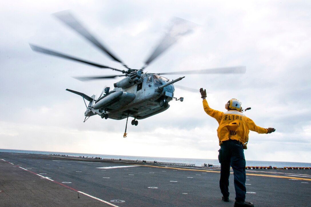 Navy Seaman Maliki Pratt signals a CH-53E Super Stallion helicopter on the flight deck of the amphibious assault ship USS Bonhomme Richard as part of a large-scale amphibious assault during exercise Talisman Saber 17 in the Coral Sea, July 13, 2017. Pratt is an aviation boatswain’s mate. The USS Bonhomme Richard is serving a U.S.-Australia-New Zealand amphibious force. Navy photo by Petty Officer 2nd Class Jeanette Mullinax