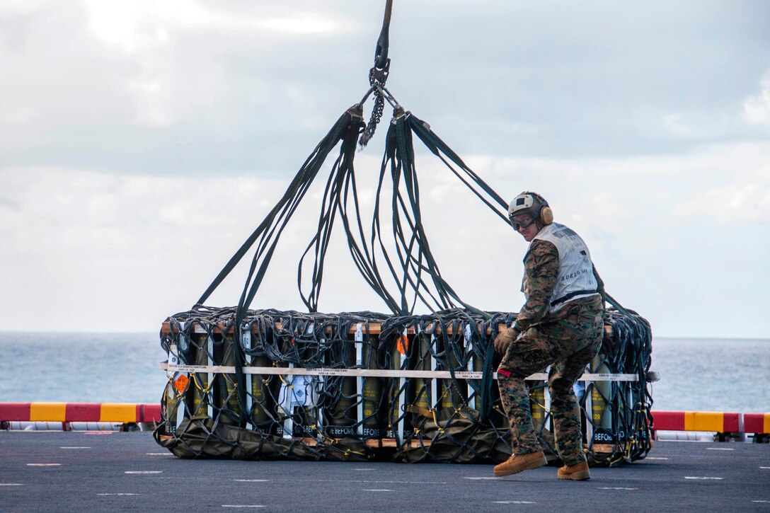 Marine Corps Cpl. John Lilly attaches ordnance pallets to a CH-53E Super Stallion helicopter on the flight deck of the amphibious assault ship USS Bonhomme Richard as part of a large-scale amphibious assault during Talisman Saber 17 in the Coral Sea, July 13, 2017. Lilly is assigned to Combat Logistics Battalion 31 of the 31st Marine Expeditionary Unit. Navy photo by Petty Officer 2nd Class Jeanette Mullinax
