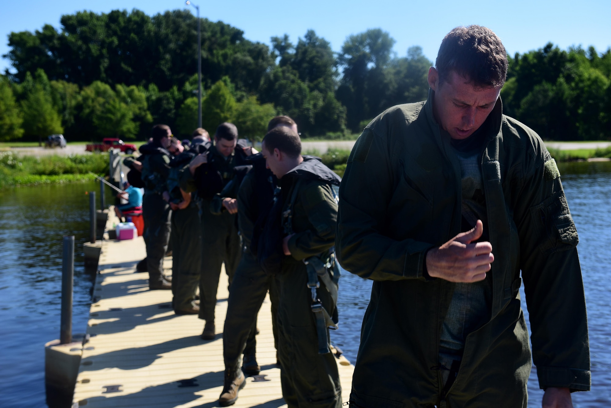 Staff Sgt. Joshua Krape, 4th Operations Support Squadron survival, evasion, resistance and escape specialist (right), pilots, and weapons systems officers from Seymour Johnson Air Force Base, North Carolina, prepare to start a water survival training course, June 28, 2017, at Buckhorn Reservoir, North Carolina. Pilots and WSO’s are required to recertify their WST and combat survival training courses every three years. (U.S. Air Force photo by Airman 1st Class Kenneth Boyton)