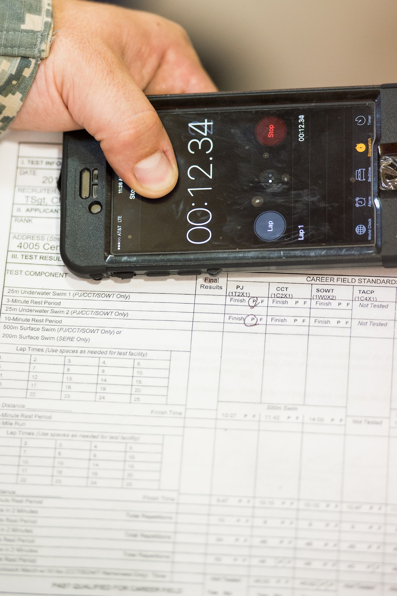 Tech. Sgt. David Cloninger, 314th Air Force Recruiting Squadron, keeps time during the running portion of the Physical Ability and Stamina test July 12, 2017, at Dover Air Force Base, Del. Although some portions of the test are scored by the number of repetitions completed each portion of the test also has a time limit. (U.S. Air Force photo by Mauricio Campino)