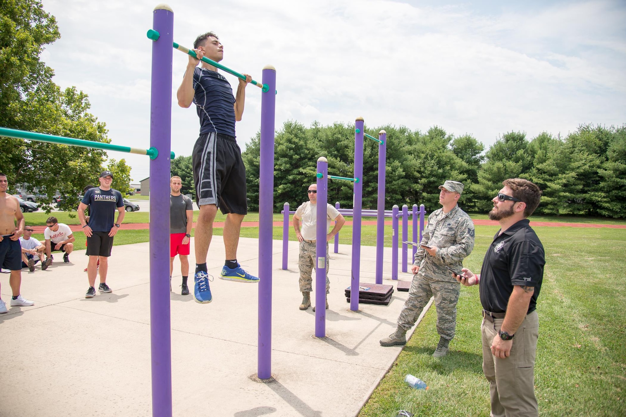 Ryan Brodton, U.S. Air Force special operations veteran, coaches Delayed Enlistment Program members through the pull-up portion of the Physical Ability and Stamina test July 12, 2017, at Dover Air Force Base, Del. Brodton currently works for T3i, a company that helps develop potential Air Force special operations candidates. (U.S. Air Force photo by Mauricio Campino)