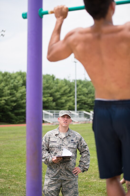 Tech. Sgt. David Cloninger, 314th Air Force Recruiting Squadron, monitors the pull-up portion of the Physical Ability and Stamina test July 12, 2017, at Dover Air Force Base, Del. Exercises that are not performed according to the strict guidelines are not counted for score. (U.S. Air Force photo by Mauricio Campino)
