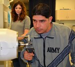 Then-Army 1st Lt. John Arroyo works on strengthening his right hand while his occupational therapist, Katie Korp, looks on at the Center for the Intrepid in Brooke Army Medical Center’s rehabilitation center at Joint Base San Antonio-Fort Sam Houston, Jan. 16, 2015. Arroyo is one of many warriors and civilians who have made tremendous strides in their recovery due to Army Medicine. 