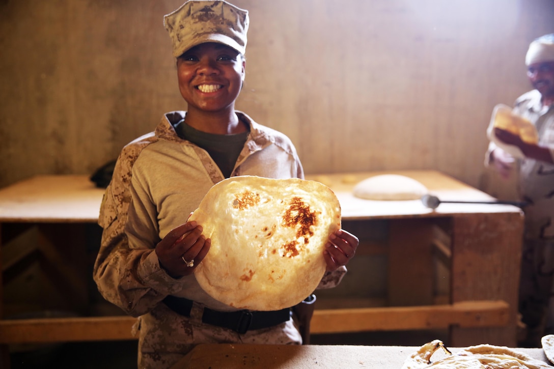 U.S. Marine Corps Staff Sgt. Shakelia Woods, a food service specialist with Special Purpose Marine Air-Ground Task Force-Crisis Response-Central Command, showcases khubuz, a traditional Iraqi flat bread, at Al Asad Air Base, Iraq, May 4, 2017.  Woods instructed Iraqi soldiers with the 7th Iraqi Army Division on capabilities and employment of an Ozti Field Kitchen (OFK) during an advise and assist mission in support of Task Force Al Asad. Task Force Al Asad trains Iraqi forces with operationally relevant training, an integral aspect of Combined Joint Task Force-Operation Inherent Resolve, the global coalition to defeat ISIS in Iraq and Syria. (U.S. Marine Corps photo by Staff Sgt. Jennifer B. Poole)