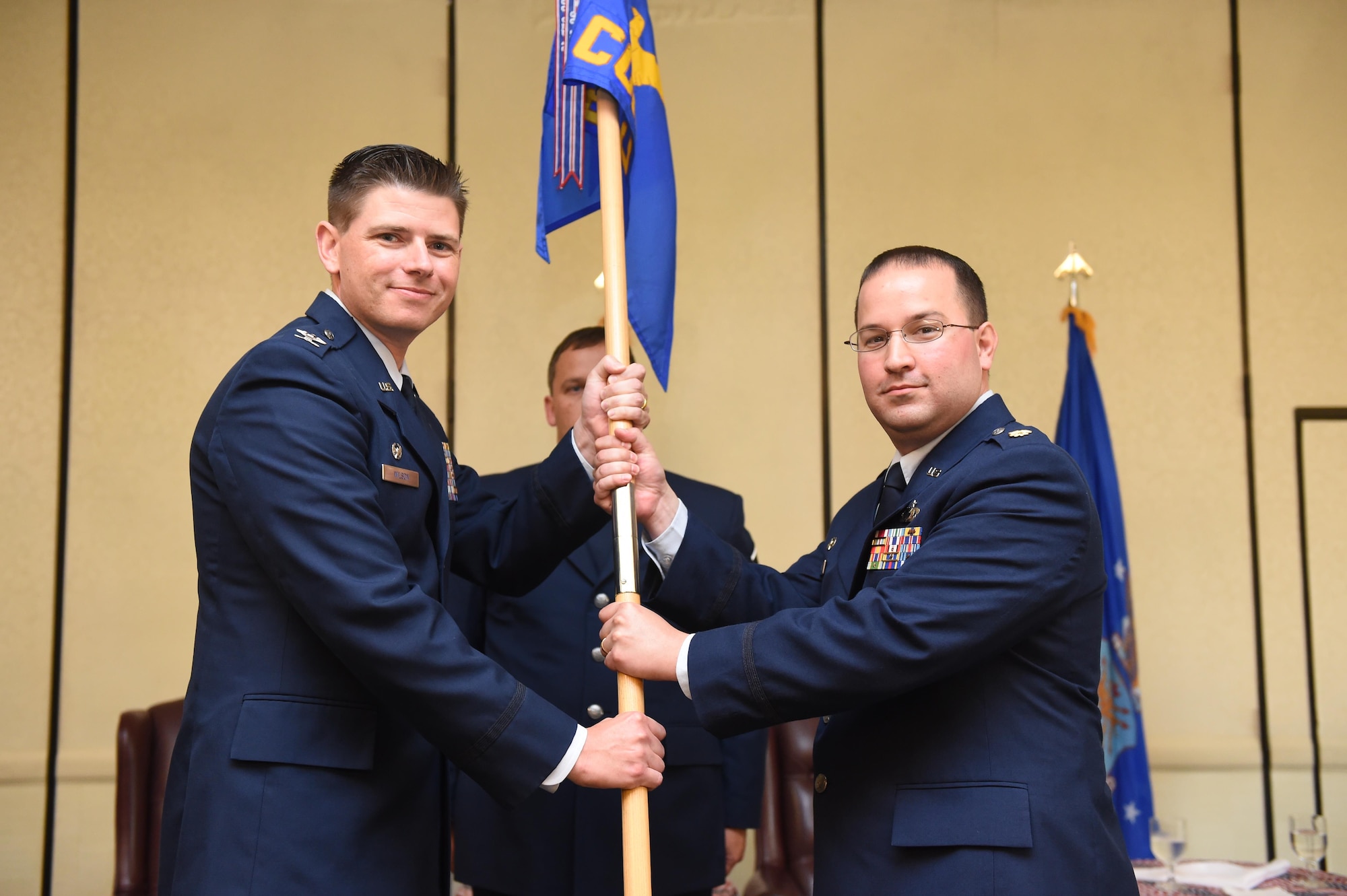 Maj. Antony Barrios, right, incoming 628th Contracting Squadron commander, takes command during a change of command ceremony officiated by Col. Rockie Wilson, left, 628th Mission Support Group commander, at the Charleston Club here, July 18, 2017. Barrios replaced Lt. Col. Rebecca Welton, outgoing commander.