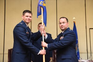 Maj. Antony Barrios, right, incoming 628th Contracting Squadron commander, takes command during a change of command ceremony officiated by Col. Rockie Wilson, left, 628th Mission Support Group commander, at the Charleston Club here, July 18, 2017. Barrios replaced Lt. Col. Rebecca Welton, outgoing commander.