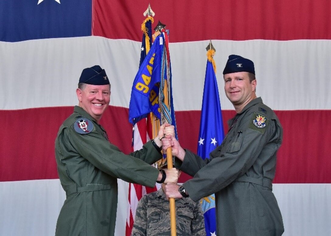 Col. Bryan Cook, 944th Fighter Wing commander, hands a guidon to Col. Korey Amundson, the new 944th Operations Group commander, July 14 during a change of command ceremony at Luke Air Force Base, Ariz. (U.S. Air Force phot by Tech. Sgt. Louis Vega Jr.)