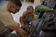Staff Sgt. Jonathan Medler supervises Senior Airman Devon Posey, both with the 932nd Airlift Wing Aerospace Ground Equipment shop, while completing an in-depth inspection on a New Generation Heater at Scott Air Force Base, Illinois on July 8, 2017. Posey verified the security of the engine block shock mounts on the heater as part of the checklist of areas to inspect. (U.S. Air Force photo by Tech. Sgt. Christopher Parr)