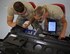 Staff Sgt. Jonathan Medler and Senior Airman Devon Posey discuss the components in the New Generation Heater and how to inspect them in accordance with the technical orders for the specific unit July 8, 2017, Scott Air Force Base, Illinois. (U.S. Air Force photo by Tech. Sgt. Christopher Parr)