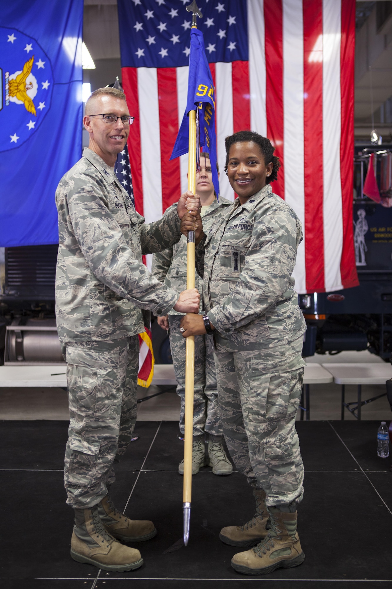 Col. Greg Buckner, 90th Maintenance Group commander, passes the guidon to Lt. Col. Stephanie Wilson, 90th Missile Maintenance Squadron commander, during the 90th MMXS assumption of command ceremony July 18, 2017, as Master Sgt. Jennifer Villela, 90th MMXS first sergeant, stands in the background on F.E. Warren Air Force Base, Wyo. The ceremony signified the transition of command from Lt. Col. Jeremy Russell to Wilson. (U.S. Air Force photo by Lan Kim)
