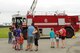 A child puts on a replica fire helmet he received from U.S. Air Force Senior Airman Cole Westbrock, a 354th Civil Engineer Squadron firefighter, July 15, 2017, at Eielson Air Force Base, Alaska. The Eielson Fire Department hosted an open house for families to educate them on emergency response vehicles. (U.S. Air Force photo by Airman Eric M. Fisher)