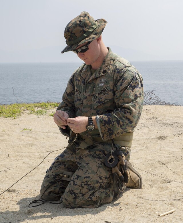 U.S. Marine Corps Staff Sgt. Chaz West, an explosive ordnance disposal (EOD) technician with Headquarters and Headquarters Squadron, prepares to conduct an explosive detonation during a training exercise at Target Island, Marine Corps Air Station Iwakuni, Japan, July 14, 2017. The training prepares EOD Marines to handle explosive threats for any aircraft incident that may happen on the installation. (U.S Marine Corps photo by Lance Cpl. Carlos Jimenez)