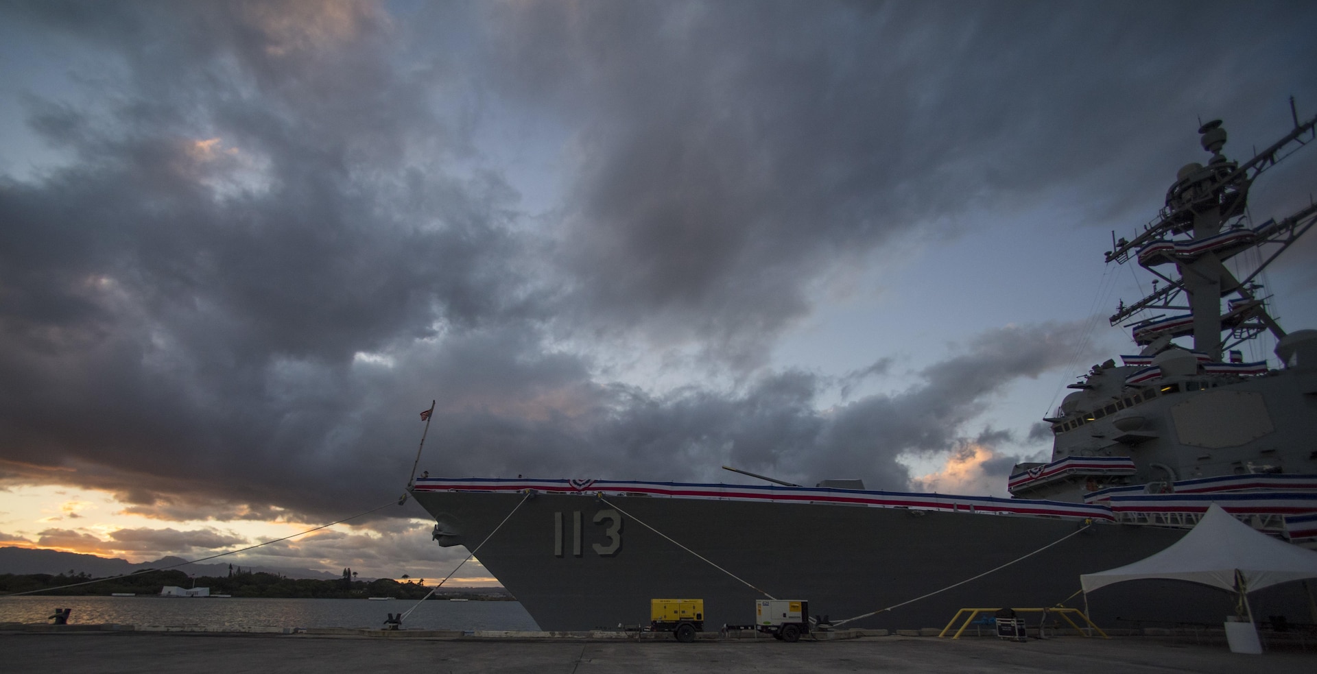 170714-N-PA426-0007 PEARL HARBOR (July 14, 2017) The sun sets on the Navy’s newest Arleigh Burke-class guided-missile destroyer, the future USS John Finn (DDG 113) July 14 in preparation for its commissioning ceremony. DDG 113 is named in honor of Lt. John William Finn, who as a chief aviation ordnanceman was the first member of our armed services to earn the Medal of Honor during World War II for heroism during the attack on Pearl Harbor. (U.S. Navy photo by MC1 Meranda Keller)