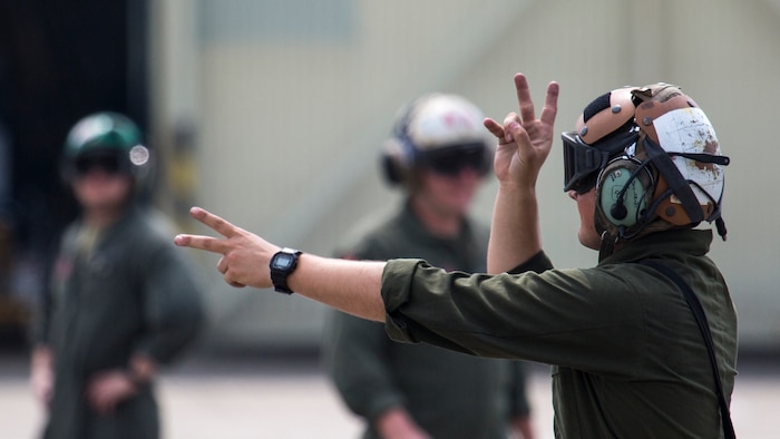 U.S. Marine Corps Lance Cpl. Jesse Schmitt, a powerlines mechanic with Marine Fighter Attack Squadron (VMFA) 232, signals to an F/A-18C Hornet pilot that he is clear to start his engines at Japan Air Self-Defense Force (JASDF) Hyakuri Air Base, Japan, July 12, 2017. VMFA-232 has been conducting exercises with the JASDF as part of the Aviation Training Relocation program, which is designed to increase operational readiness and interoperability between U.S. and Japanese forces. It reduces local noise impacts by dispersing unilateral jet-fighter training of U.S. forces in Japan. (U.S. Marine Corps photo by Lance Cpl. Mason Roy)