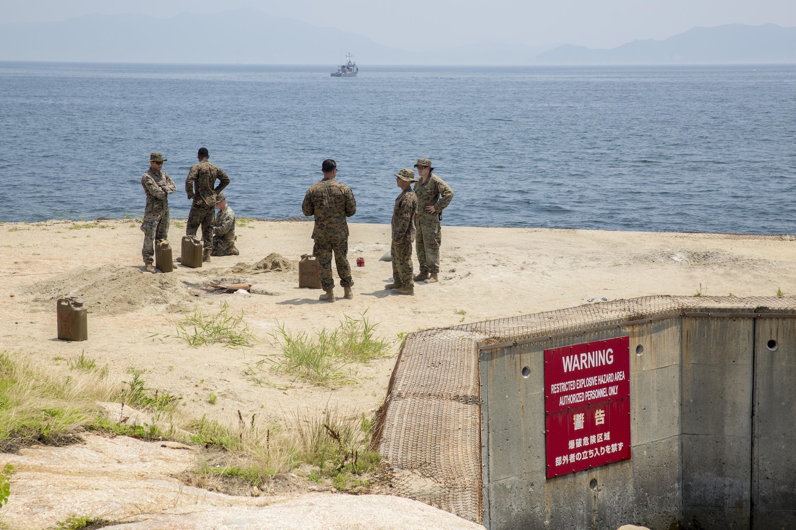 Explosive ordnance disposal Marines with Headquarters and Headquarters Squadron prepare to conduct a simulated gasoline explosion at Target Island, Marine Corps Air Station Iwakuni, Japan, July 14, 2017. The training allows the Marines to prepare for unexpected aircraft calamities or gasoline bomb explosions. (U.S Marine Corps photo by Lance Cpl. Carlos Jimenez)