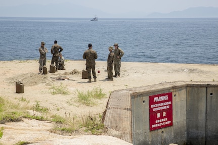 Explosive ordnance disposal Marines with Headquarters and Headquarters Squadron prepare to conduct a simulated gasoline explosion at Target Island, Marine Corps Air Station Iwakuni, Japan, July 14, 2017. The training allows the Marines to prepare for unexpected aircraft calamities or gasoline bomb explosions. (U.S Marine Corps photo by Lance Cpl. Carlos Jimenez)