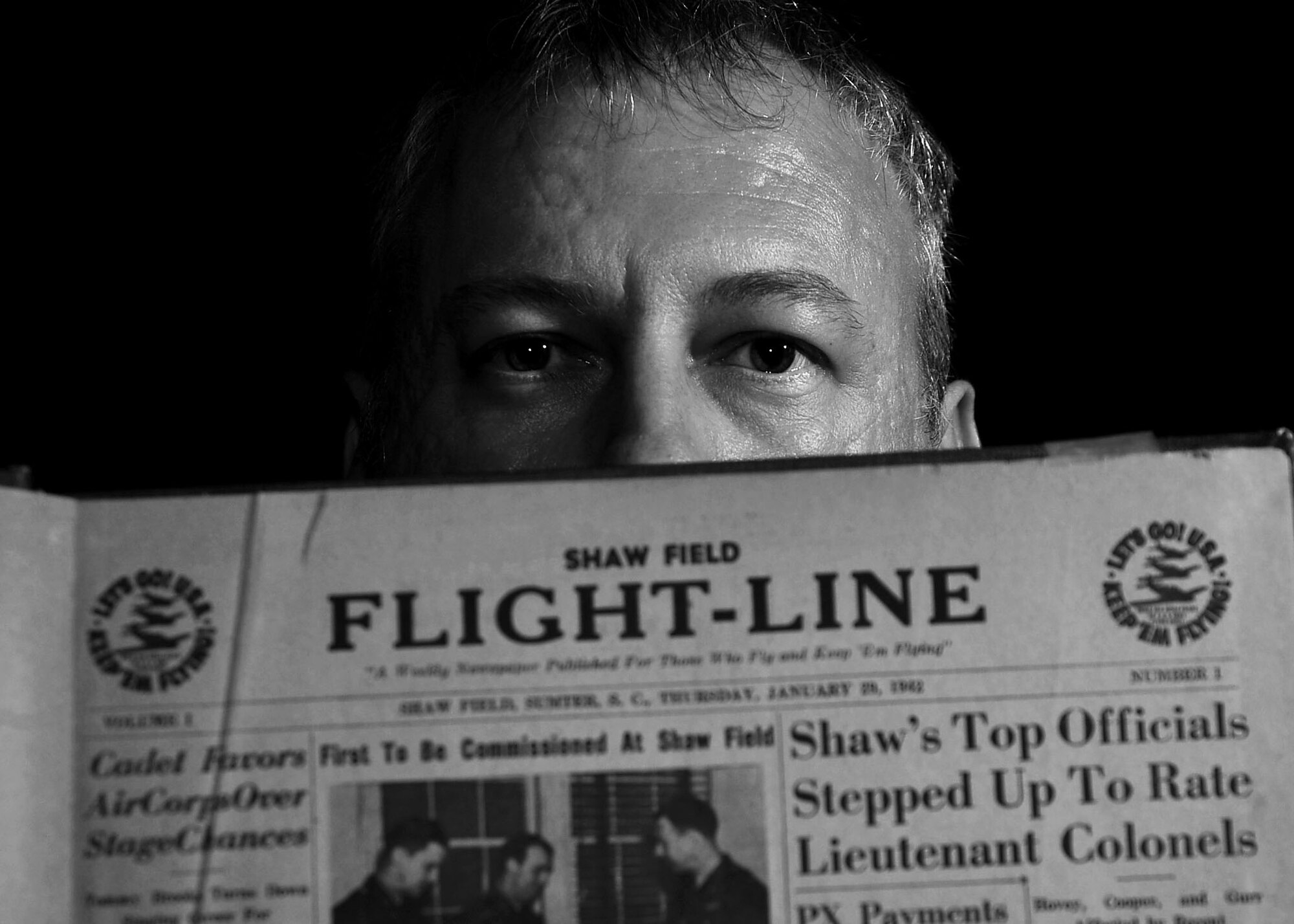 Christopher Koonce, 20th Fighter Wing historian, holds a 1942 edition of the Shaw Field Flight-Line newspaper at Shaw Air Force Base, S.C., July 12, 2017. As the wing historian, Koonce documents the ever-changing warfighter environment, at home and while deployed, by gathering data in historical documents, writing in archives and sharing knowledge with others. (U.S. Air Force photo illustration by Airman 1st Class Kathryn R.C. Reaves)