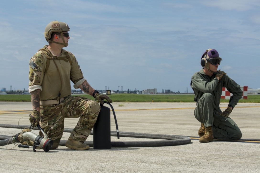 Air Force Staff Sgt. Mark Goddard and Lance Cpl. Westley W. Joints await the arrival of an F-35B Lightning II aircraft with Marine Fighter Attack Squadron 121 at Kadena Air Force Base, Okinawa, Japan, June 27, 2017. The Marines and Airmen perform hot pit refuels. Goddard is a bulk fuel specialist with 18th Logistics and Readiness Squadron, 353 Special Operations Group, 18th Wing. Joints is a bulk fuel specialist with Marine Wing Support Squadron 172, Marine Aircraft Group 36, 1st Marine Aircraft Wing, III Marine Expeditionary Force. VMFA-121 is based out of Iwakuni, Japan. The two-day exercise enabled the U.S. Air Force and Marine Corps to improve interoperability and develop tactics, techniques and procedures involving the new aircraft for future joint FARP operations throughout the Indo-Asia Pacific Theater. (U.S. Marine Corps photo by Lance Cpl. Deseree Kamm) 
