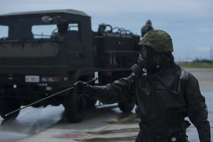 A Japanese Ground Self-Defense service member directs a decontamination truck during a simulated joint study with U.S. Marine chemical, biological, radiological and nuclear defense specialists from Marine Wing Headquarters Squadron 1 at Marine Corps Air Station Futenma, Okinawa, Japan, July 13, 2017. The joint study tests Marines' and JGSDF CBRN response capabilities. The simulated mission affords Marines and JGSDF soldiers the opportunity to show each other their capabilities and to strengthen their relationship. The JGSDF service member is with 15th Nuclear, Biological, Chemical Defense Unit (U.S. Marine Corps photo by Cpl. Kelsey Dornfeld). 