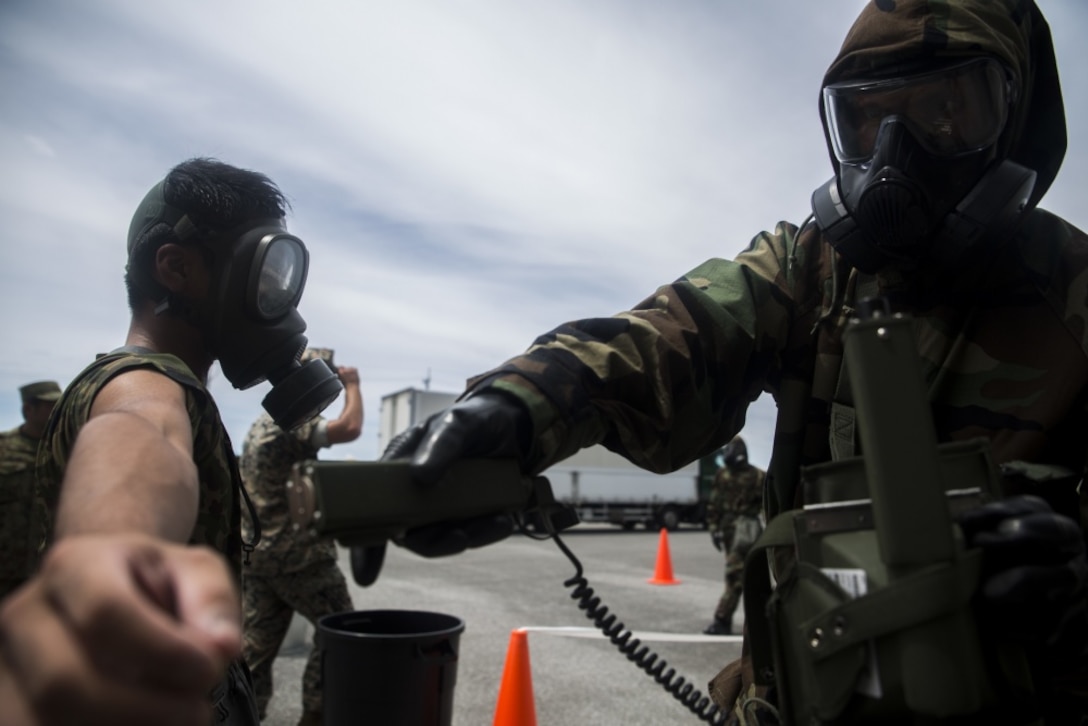 U.S. Marine Cpl. Varun Chethan scans a Japanese Ground Self-Defense member for chemicals during a simulated joint study with the JGSDF at Marine Corps Air Station Futenma on July 13, 2017. The events tests Marines' and JGSDF chemical, biological, radiological and nuclear response capabilities to a chemical attack on a flight line. This three day study allowed the service members the opportunity to share their capabilities and work together. Chethan, a native of Ann Arbor, Michigan, is a CBRN defense specialist with Marine Wing Headquarters Squadron 1, and the JGSDF service member is with 15th Nuclear, Biological, Chemical Defense Unit (U.S. Marine Corps photo by Cpl. Kelsey Dornfeld). 