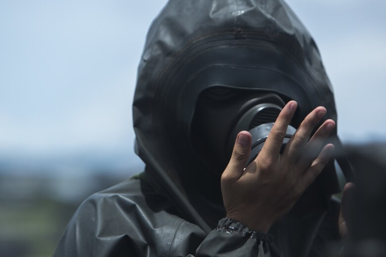 A Japanese Ground Self-Defense service member clears his gas mask in preparation to enter a contaminated airstrip during a simulated joint study with U.S. Marine chemical, biological, radiological, nuclear defense specialists from Marine Wing Headquarters Squadron 1 at Marine Corps Air Station Futenma, Okinawa, Japan, on July 13, 2017. The simulated mission affords Marines and JGSDF service members the opportunity to show each other their capabilities and become a better fighting force. The JGSDF service member is with 15th Nuclear, Biological, Chemical Defense Unit (U.S. Marine Corps photo by Cpl. Kelsey Dornfeld). 