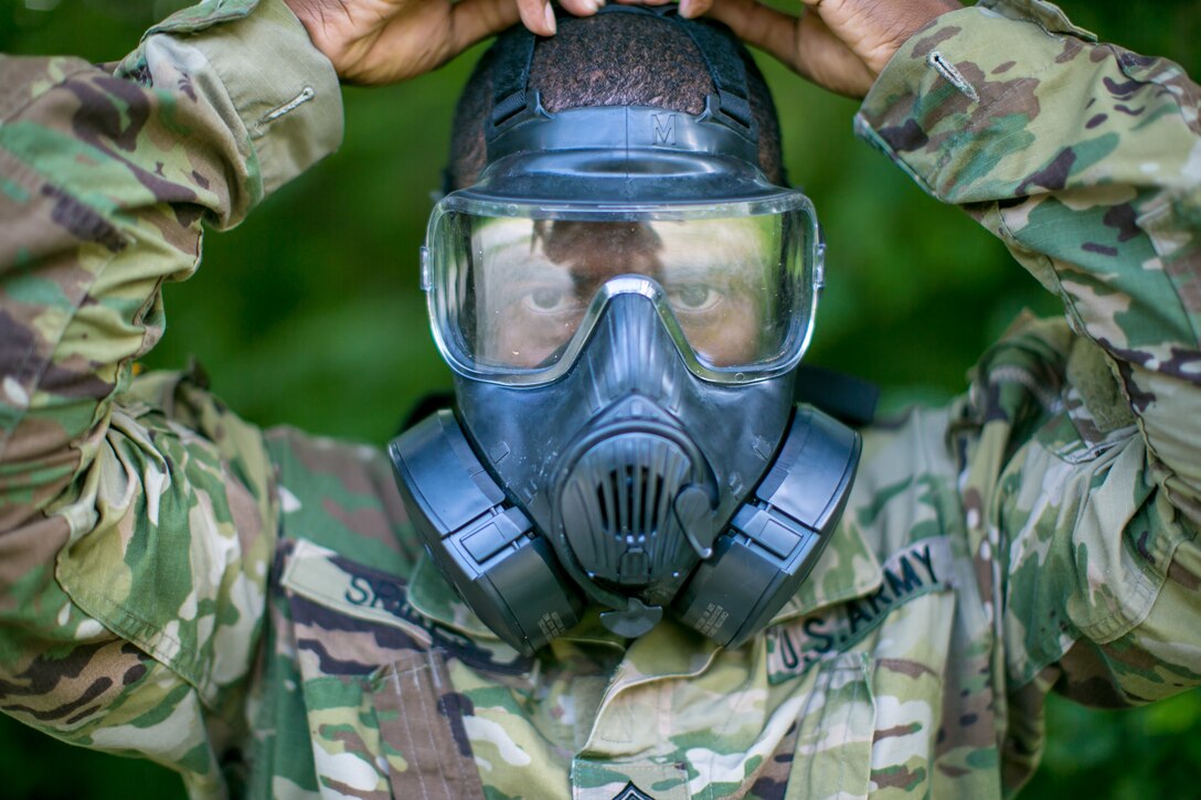 Army Sgt. 1st Class Joaquin Spikes securely straps a gas mask during a chemical, biological, radiological and nuclear scenario at Camp Atterbury, Ind., July 17, 2017, during the 2017 Army Materiel Command's Best Warrior Competition. Spikes is assigned to the U.S. Army Security Assistance Command. Army photo by Sgt. 1st Class Teddy Wade