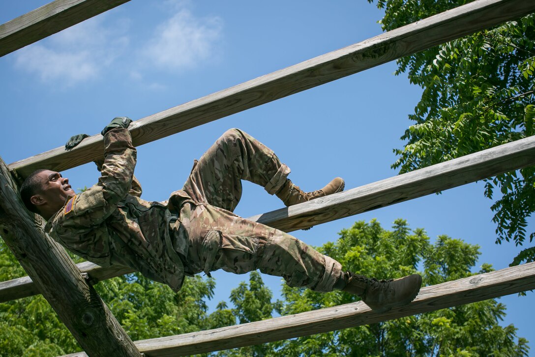 Army Staff Sgt. Qujuan Baptiste tackles an obstacle at Camp Atterbury, Ind., July 17, 2017, during the 2017 Army Materiel Command's Best Warrior Competition. Baptiste is assigned to the Army Sustainment Command. Army photo by Sgt. 1st Class Teddy Wade