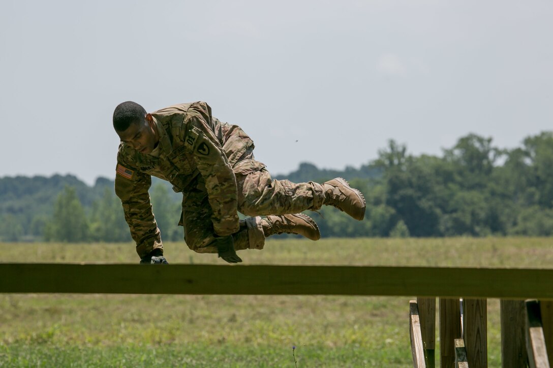 Army Staff Sgt. Qujuan Baptiste jumps over a hurdle at Camp Atterbury, Ind., July 17, 2017, during the 2017 Army Materiel Command's Best Warrior Competition. Baptiste is assigned to the Army Sustainment Command. Army photo by Sgt. 1st Class Teddy Wade