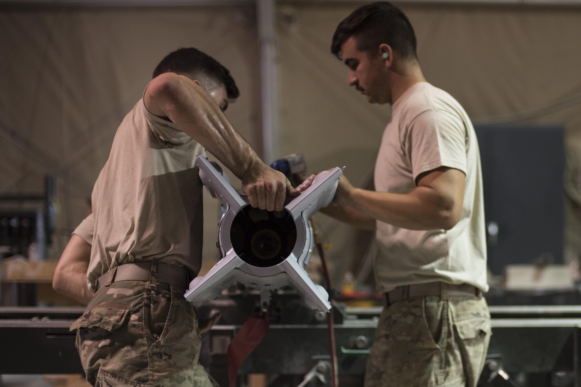 Staff Sgt. Noah Dankocsik, left, and Senior Airman Stefan Fleury, 332nd Expeditionary Maintenance Squadron maintenance crewmembers, install a tail kit to a GBU-12 laser-guided bomb July 7, 2017, in Southwest Asia. The 332nd EMXS must build a variety of bombs to combat the wide range of threats throughout the area of operation. (U.S. Air Force photo/Senior Airman Damon Kasberg)