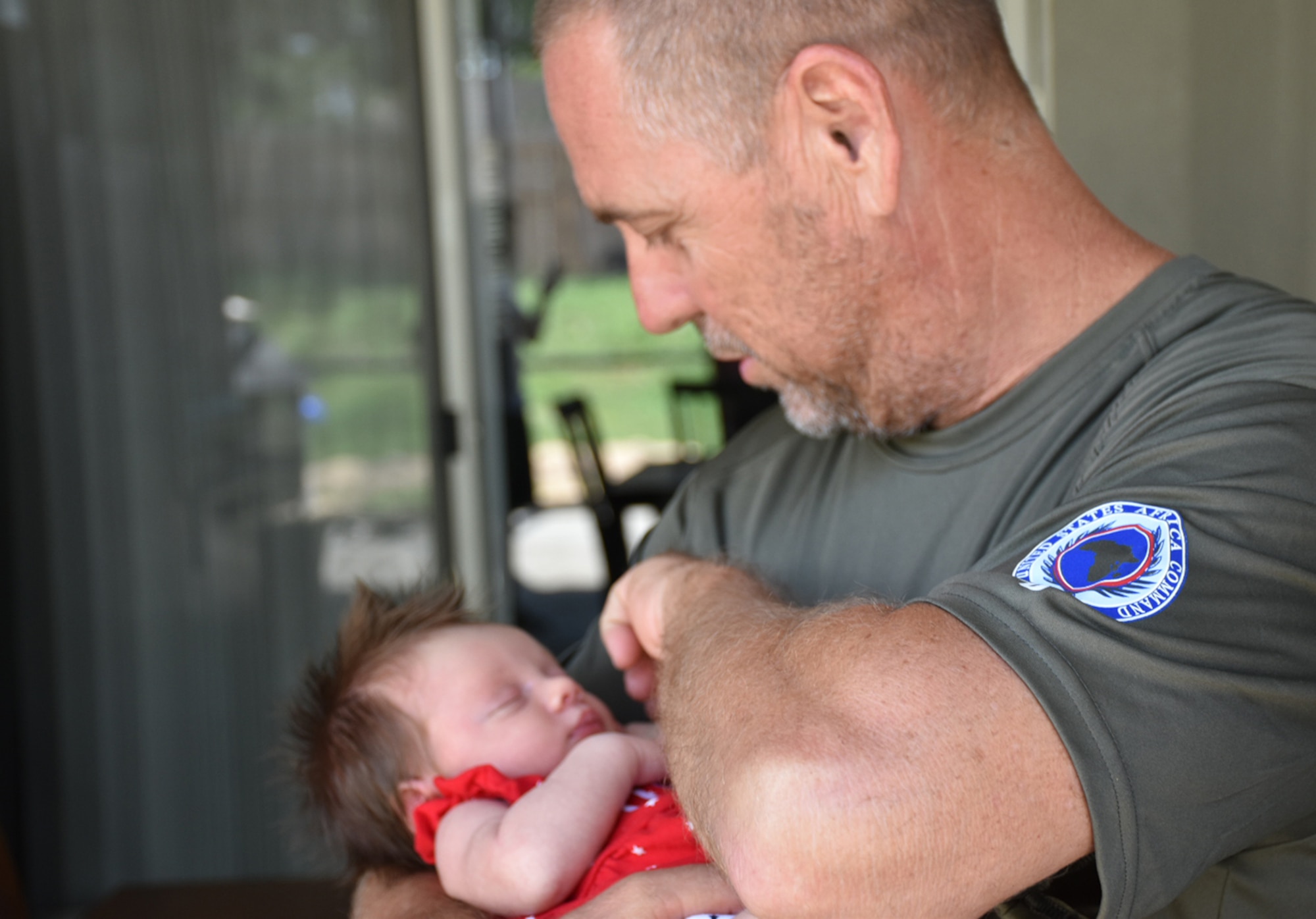 Tech. Sgt. Jeff A. Parrish, 920th Maintenance Squadron munitions assistant flight chief, holds his granddaughter, Raelynn Noelle Parrish, July 4, 2017 at his son's home in Ocoee, Florida, several weeks after returning home from a four-month deployment to the Horn of Africa. (Courtesy photo)